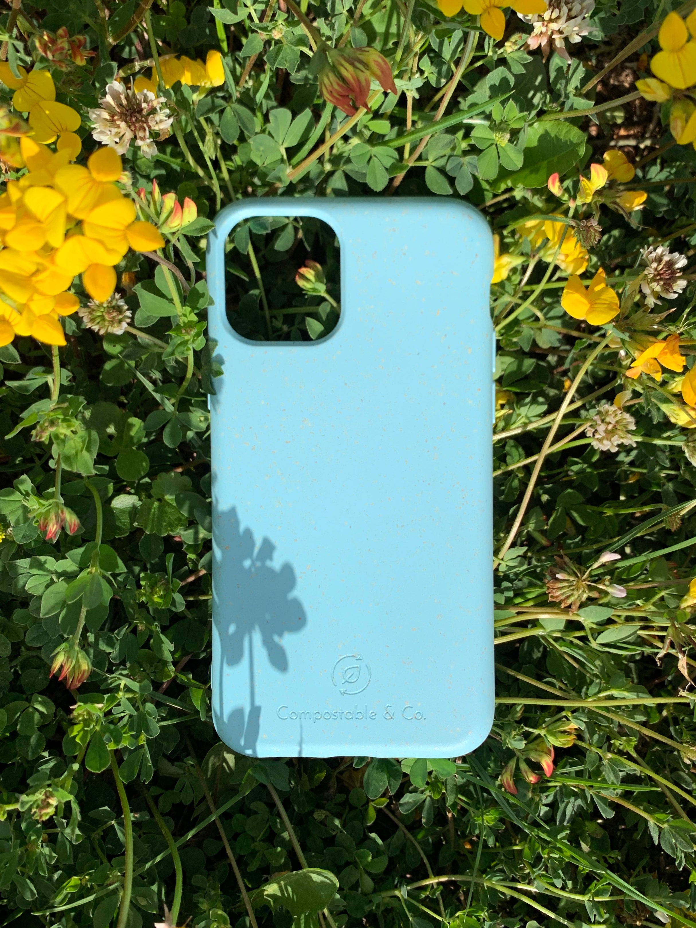 Compostable & Co. iPhone 11 pro blue biodegradable phone case with natural background