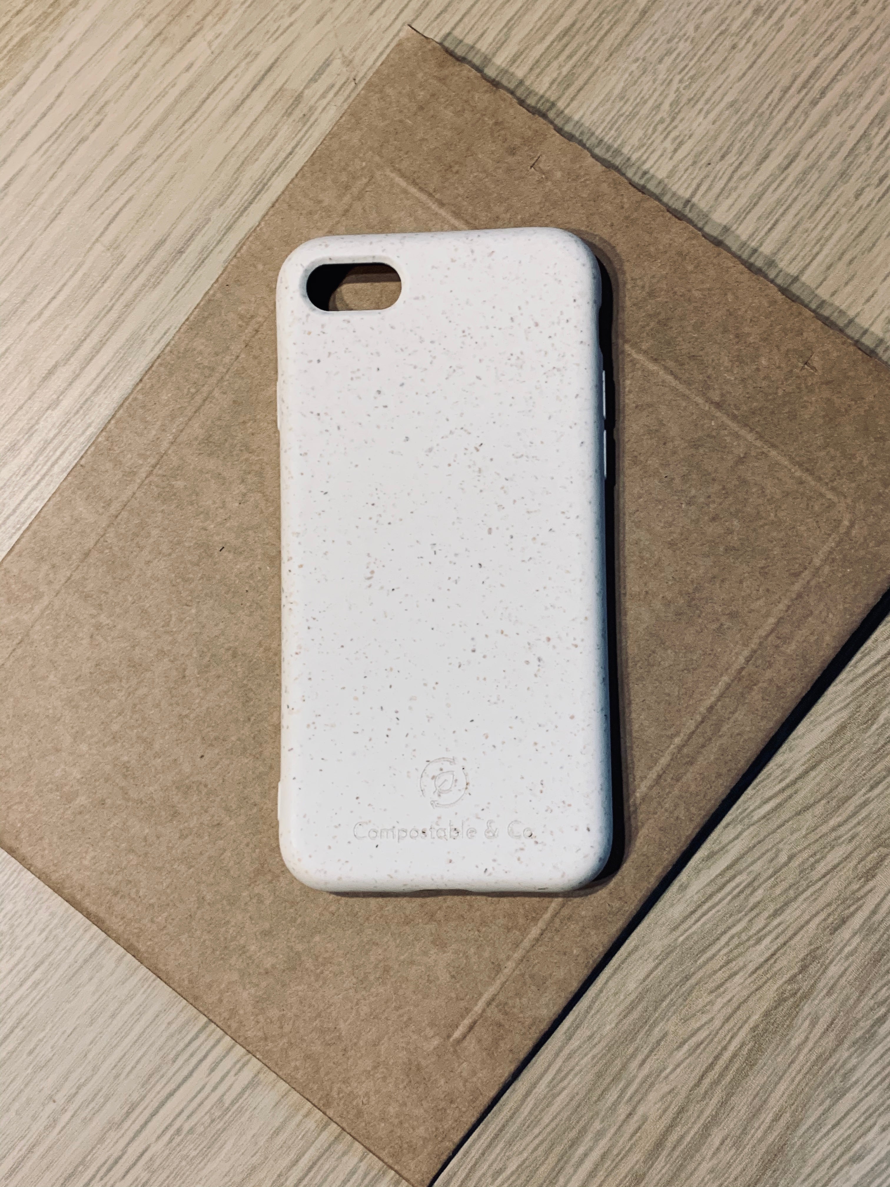 Compostable & Co. iPhone 7 / 8 / SE 2020 white biodegradable phone case with recycled paper background